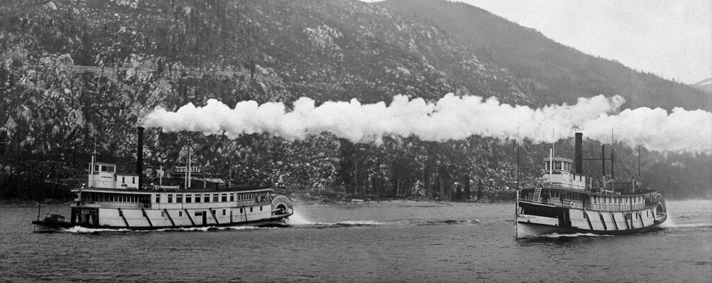 The International (left) and the Kokanee (right) battling it out on the West Arm shortly after leaving Nelson. The shoreline visible between the two steamers is Bealby Point. Photograph courtesy of the Kootenay Lake Archives. 
