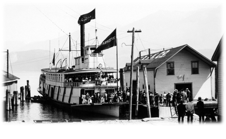  Crowds of excursionists dressed in their best attire boarding the International at Kaslo’s 3rd Street wharf, near where the Moyie rests today. The wharf shed on the left belongs to the CPR, while the one on the right is owned by the Kootenay Railway & Navigation Co. 
